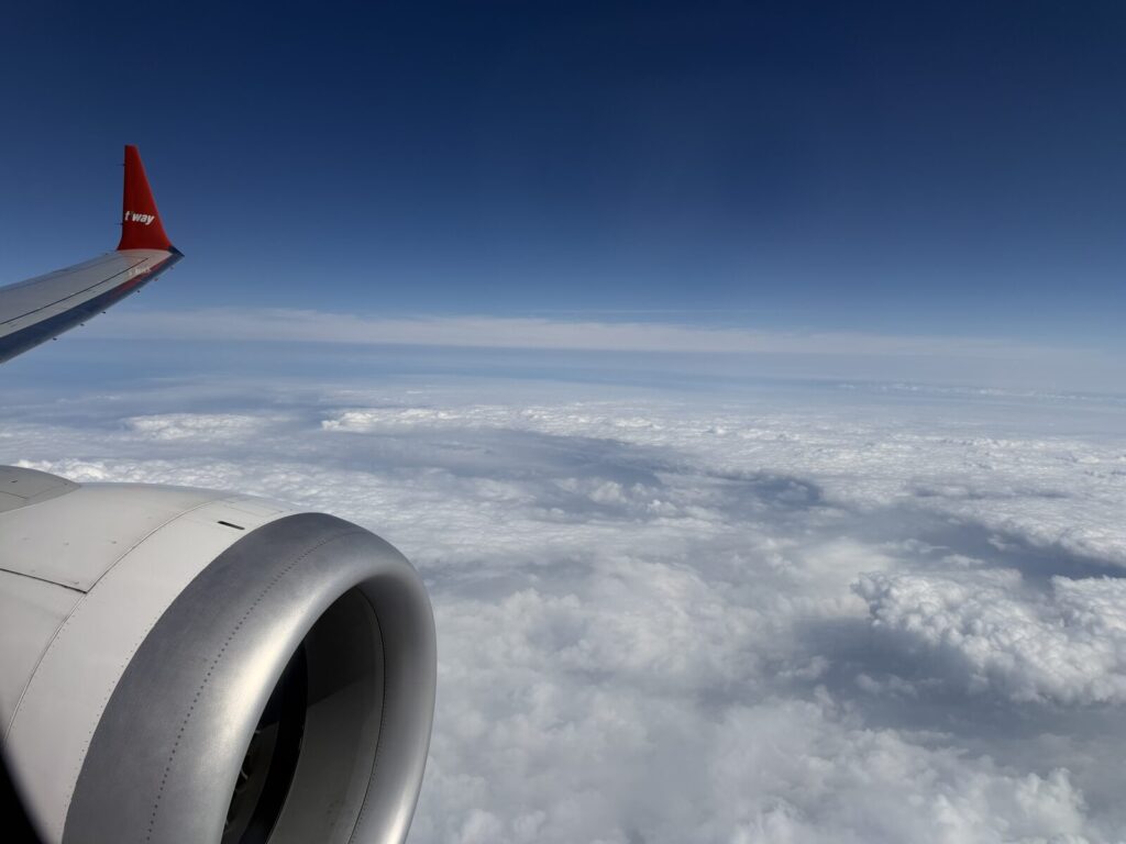 雲海の上を飛ぶティーウェイ航空の主翼とエンジン